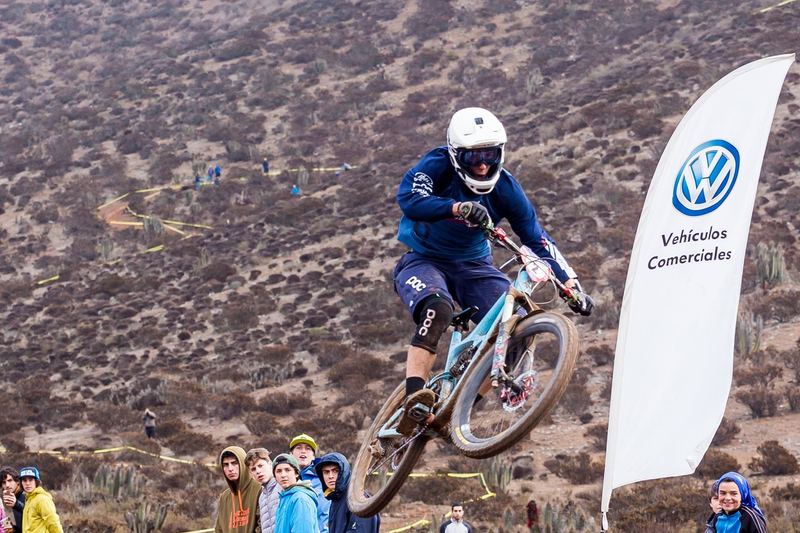 Mountain bike rider jumping a dirt kicker at an enduro race in Chile (photo 1 of 19)