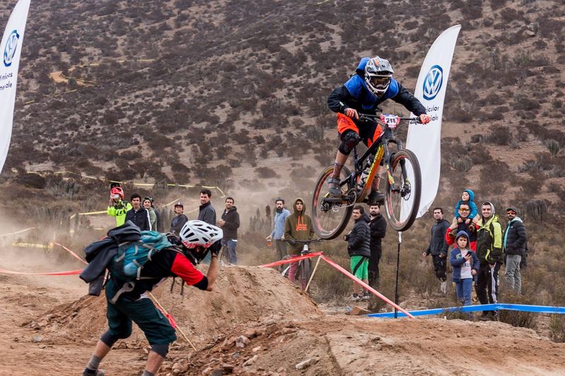 Mountain bike rider jumping a dirt kicker at an enduro race in Chile (photo 9 of 19)