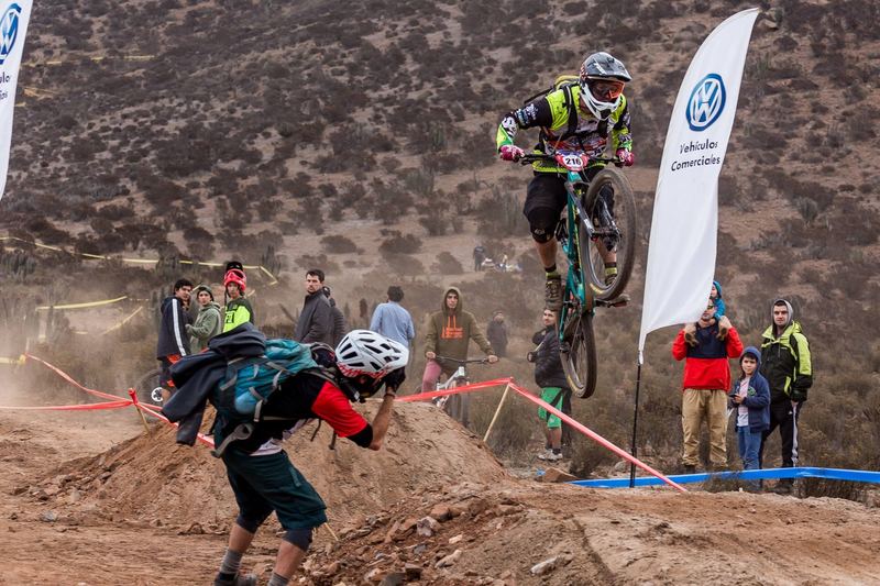 Mountain bike rider jumping a dirt kicker at an enduro race in Chile (photo 10 of 19)