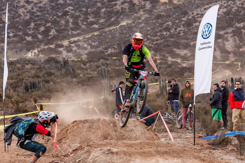 Mountain bike rider jumping a dirt kicker at an enduro race in Chile (photo 11 of 19)