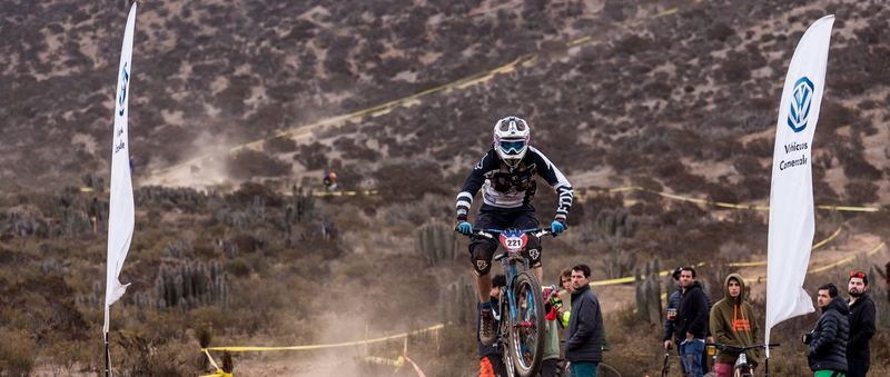 Mountain bike rider jumping a dirt kicker at an enduro race in Chile (photo 12 of 19)