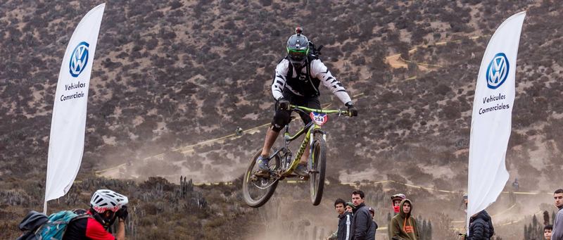 Mountain bike rider jumping a dirt kicker at an enduro race in Chile (photo 15 of 19)