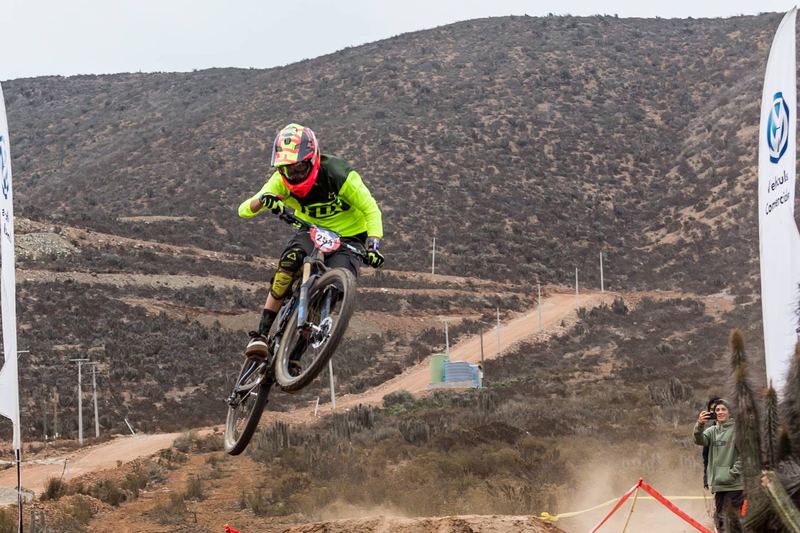 Mountain bike rider jumping a dirt kicker at an enduro race in Chile (photo 16 of 19)
