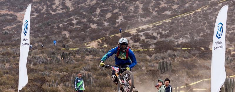 Mountain bike rider jumping a dirt kicker at an enduro race in Chile (photo 18 of 19)